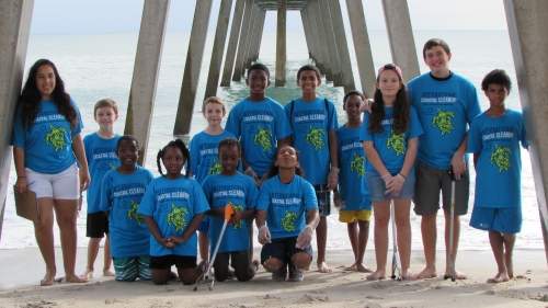 Children smiling outside in their blue shirts